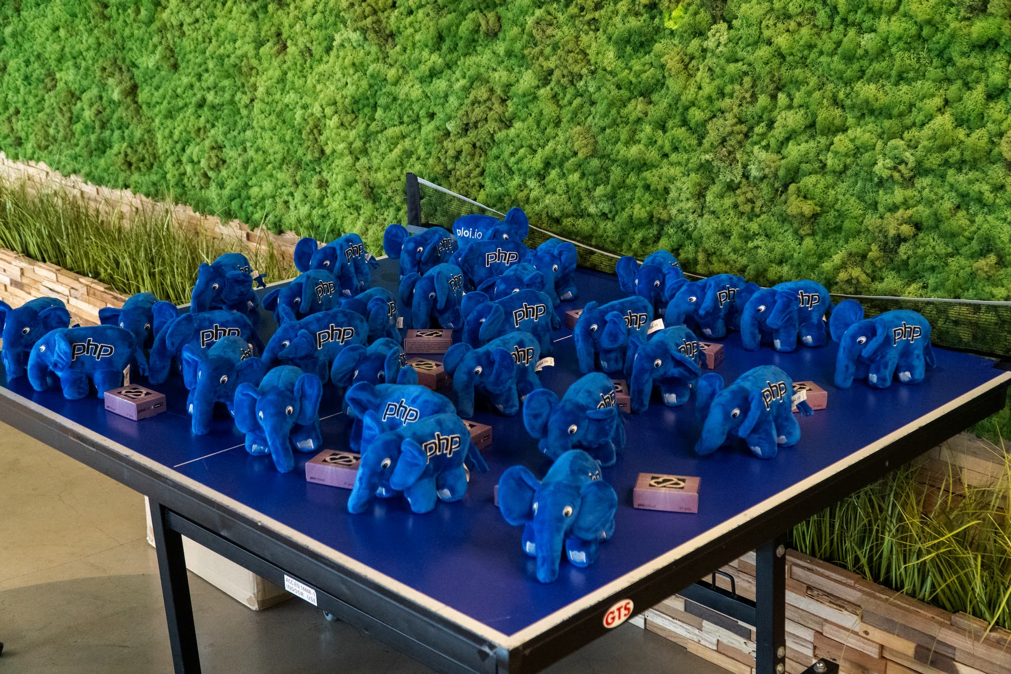 A table full of blue Ploi.oi themed elePHPants, the plush toy and mascot of the PHP programming language